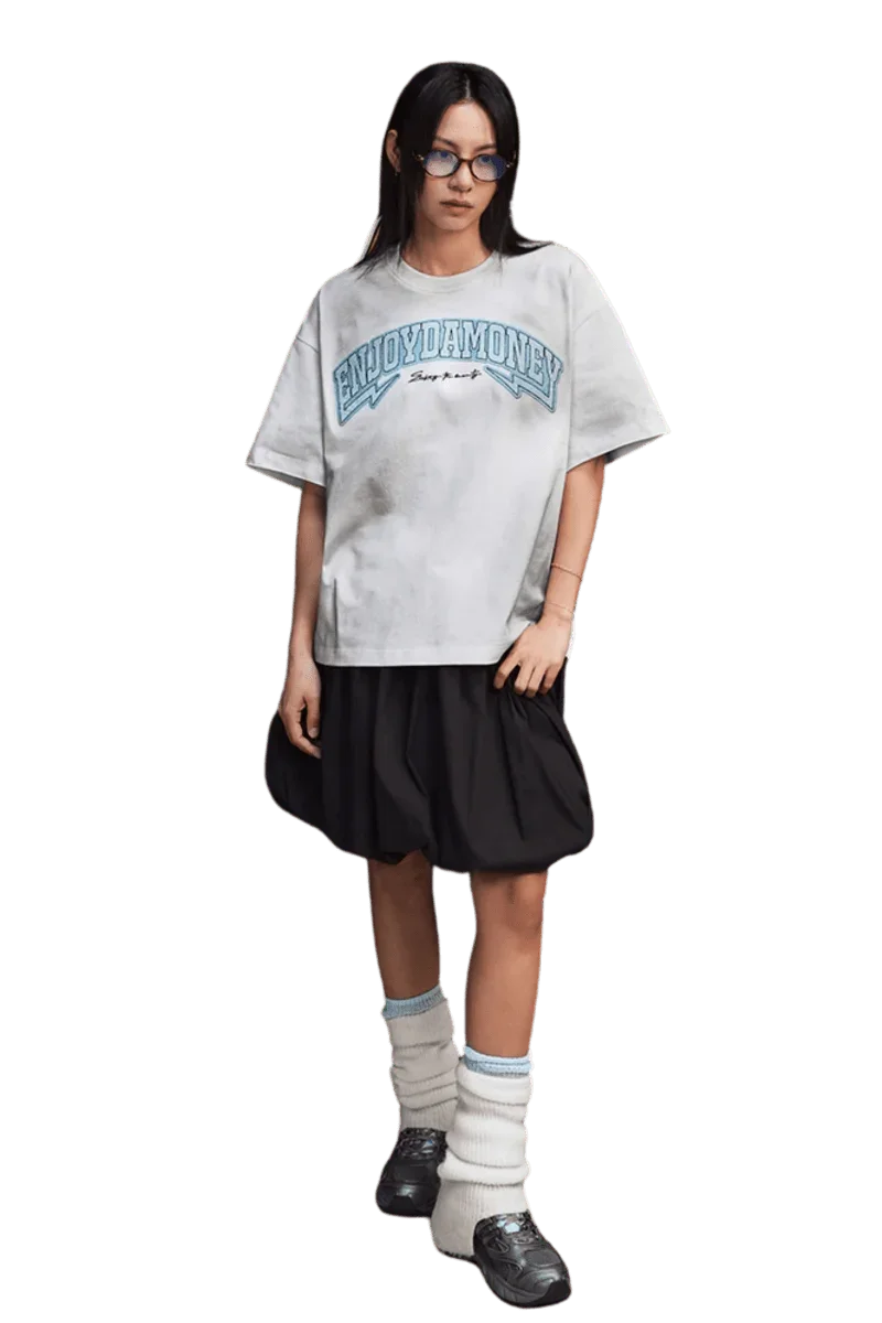 MEDM SS25 Washed Arch Logo Tee in gray on model, paired with a black skirt and stylish accessories