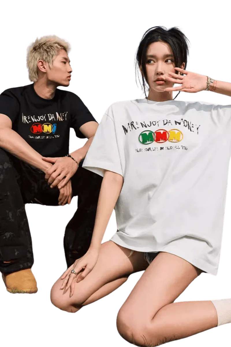Model wearing the MEDM Triple M Embossed Tee in white, paired with casual shorts for a trendy look