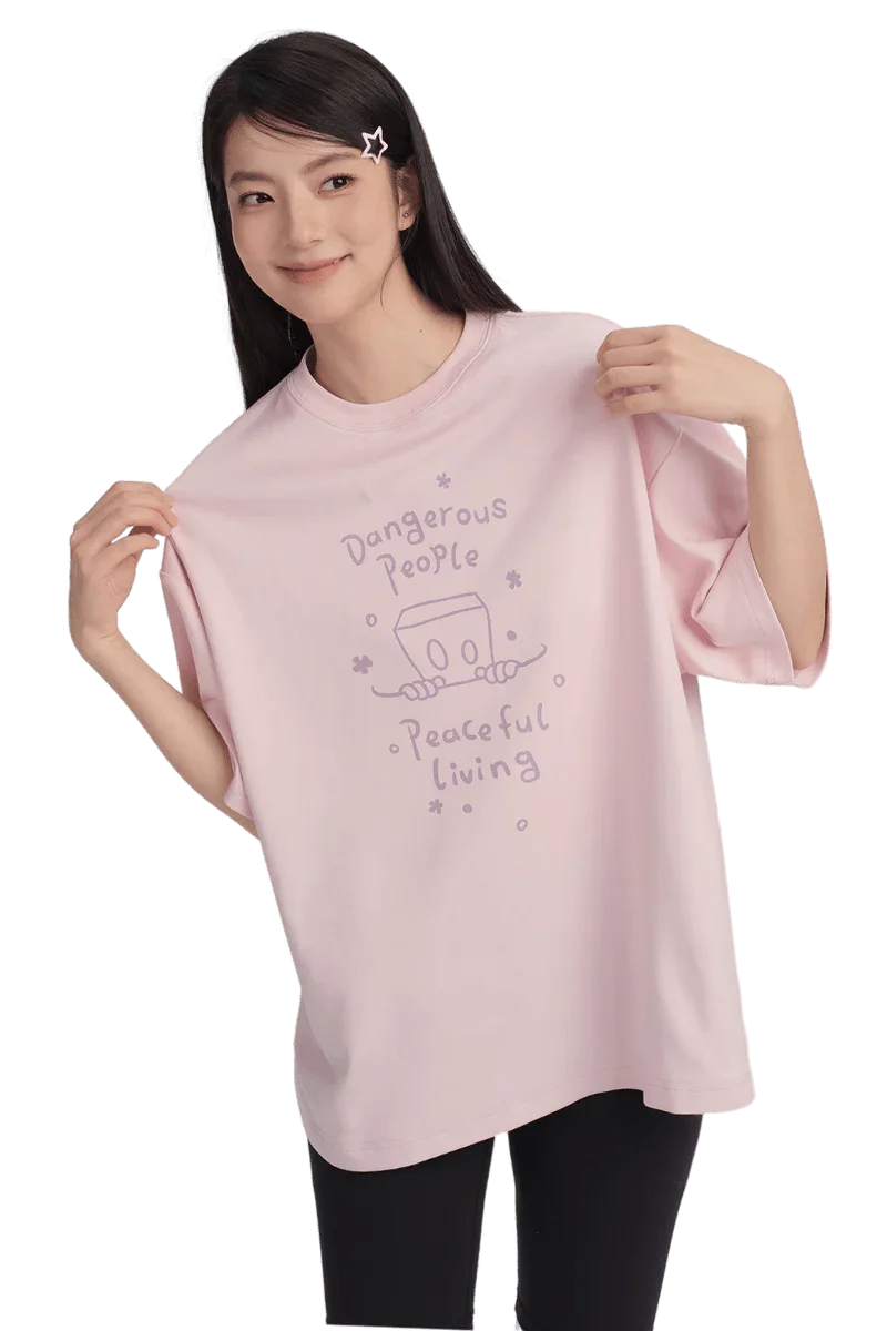 Model wearing Dangerous People Peaceful Living Hand Painted Tee in soft pink color