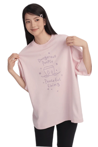 Model wearing Dangerous People Peaceful Living Hand Painted Tee in soft pink color