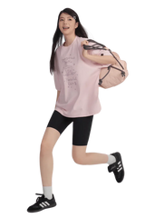 Model wearing a pink Peaceful Living Hand Painted Tee with black shorts and a backpack for a casual look
