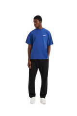 Men's blue Represent Owners Club T-Shirt styled with black pants for a casual look