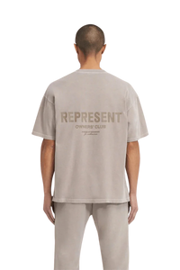 Back view of a man wearing the SS24 Owners Club Rubber Logo T-Shirt in light gray with bold logo design