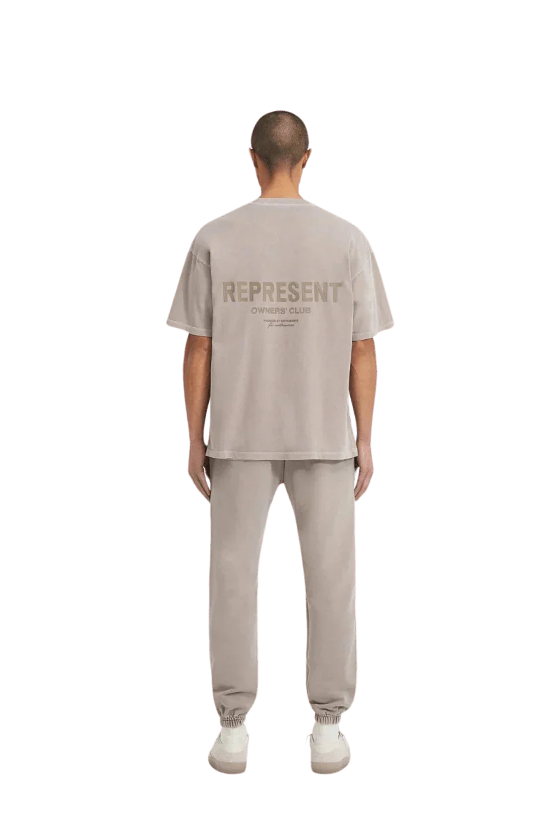 Back view of SS24 Owners Club Rubber Logo T-Shirt in light gray by Represent, styled with matching joggers