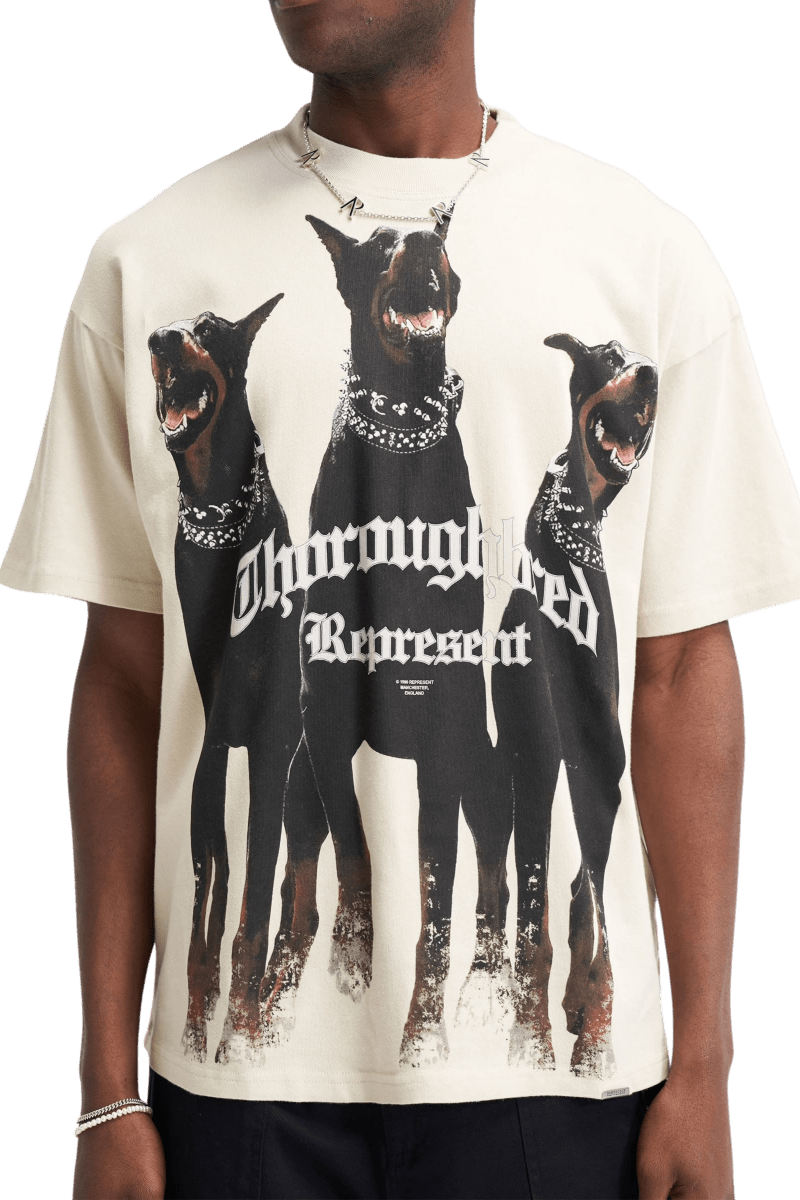 Represent Thoroughbred Tee featuring graphic of three Doberman dogs in bold design on a cream background