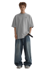Masonprince Small Logo Basic Tee in gray worn with loose blue jeans and sneakers on male model