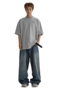 Masonprince Small Logo Basic Tee in gray worn with loose blue jeans and sneakers on male model