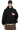 Fear Of God Essentials SS24 Heavy Jersey Arch Logo Hoodie in black, worn with a cap and stylish bag