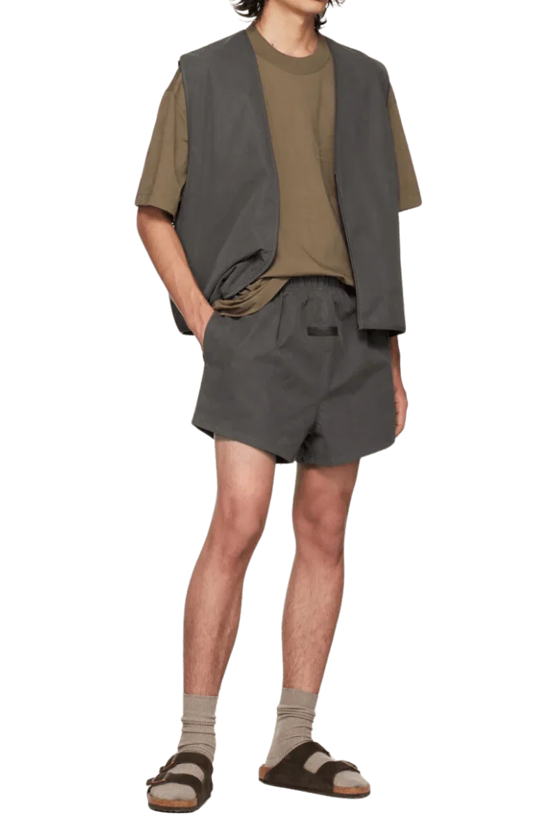 Fear Of God Essentials FW22 Flock Logo Tee displayed with matching shorts and vest for a stylish look