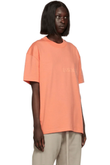 Fear Of God Essentials FW22 Flock Logo Tee in Peach Color with Relaxed Fit Design
