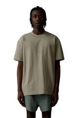 Fear Of God Essentials SS23 Rubber Embossed Tee in a neutral color worn by a model