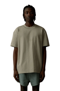 Fear Of God Essentials SS23 Rubber Embossed Tee in a neutral color worn by a model